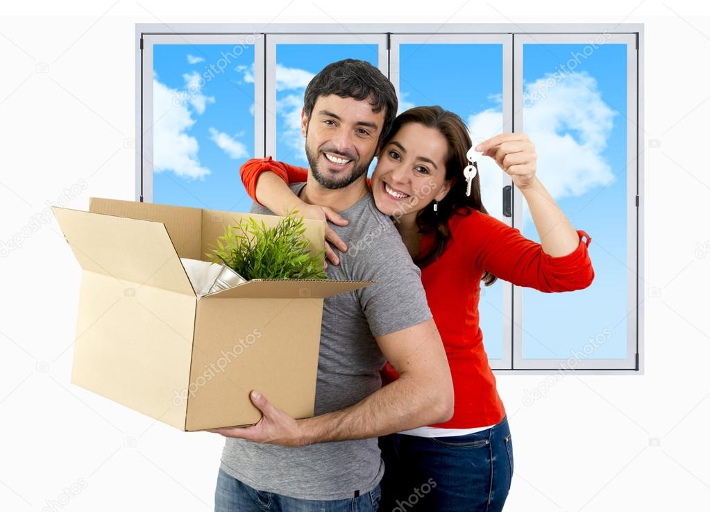 happy couple moving together in a new house unpacking cardboard 