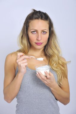 Diyet sağlıklı beslenmesinde doğal krem yoğurt yemek kaşık ile genç seksi ve çekici sarışın kız