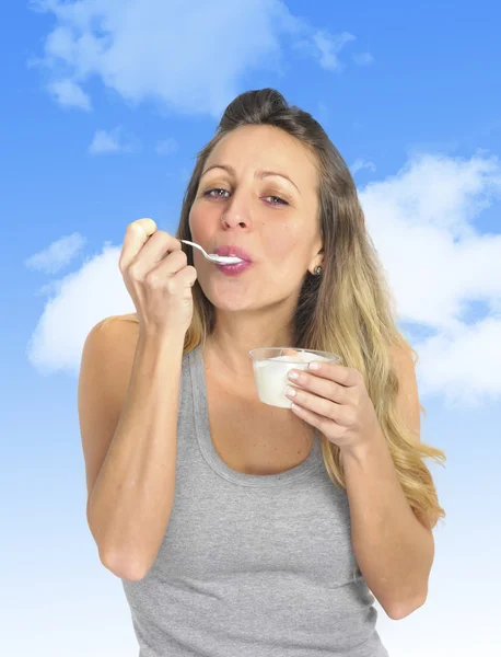 Giovane ragazza bionda sexy e attraente con cucchiaio mangiare yogurt alla panna naturale nella dieta nutrizione sana — Foto Stock
