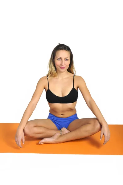 Jovem sexy atraente mulher em forma no ginásio fazendo ioga exercício e posição sentada no tapete em meditação e relaxar — Fotografia de Stock