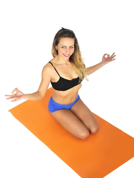 Young sexy attractive fit woman at gym doing yoga exercise and position sitting on mat in meditation and relax — Stock Photo, Image