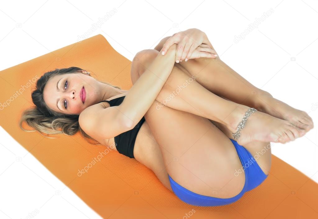 Young sexy attractive fit woman at gym doing yoga exercise and position  sitting on mat in meditation and relax Stock Photo by ©focuspocusltd  67644781
