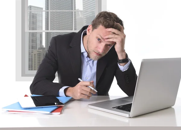 Привлекательный бизнесмен, работающий в стрессе за офисным настольным компьютером — стоковое фото