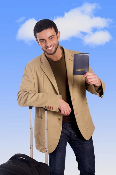 Attraente viaggiatore uomo appoggiato sul bagaglio custodia in possesso di passaporto sorridente felice e fiducioso — Foto Stock