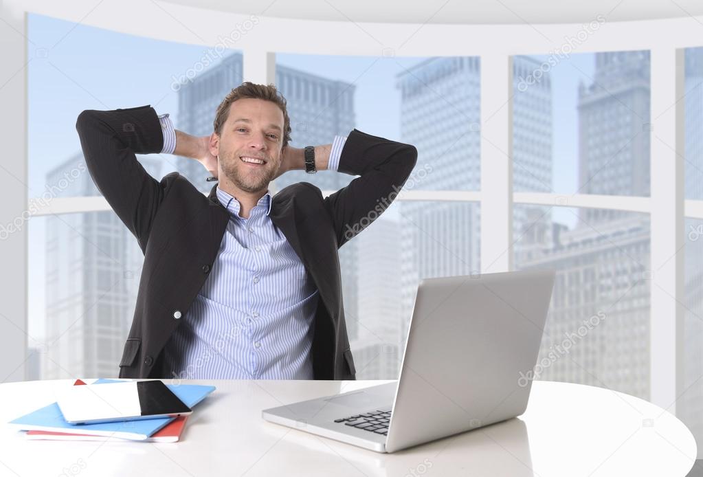 attractive businessman happy at work smiling relaxed at computer business district office