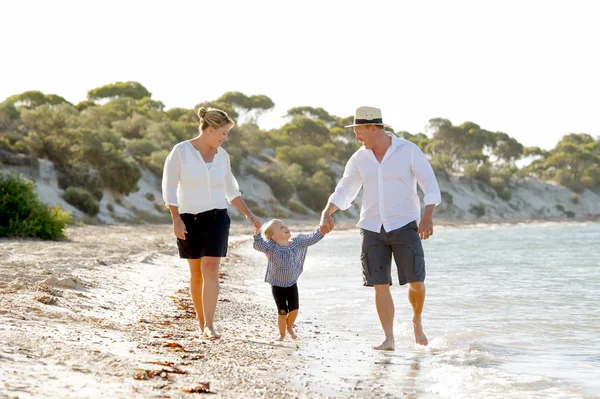 Joven feliz madre y padre caminando en la playa en concepto de vacaciones familiares — Foto de Stock