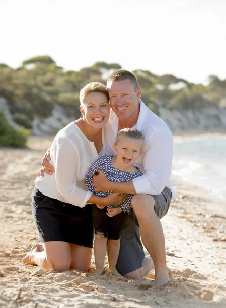 Beautiful family couple wife and husband holding little daughter on beach — Stock Photo, Image