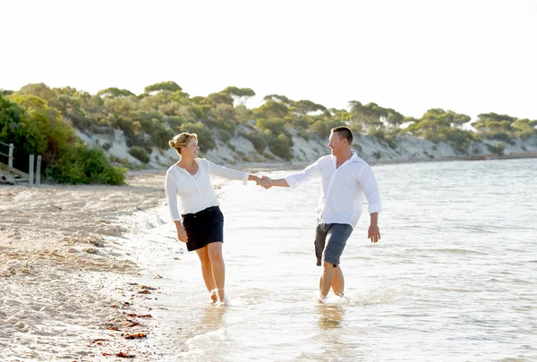 Привлекательная красивая пара влюбленных прогулок по пляжу в романтические летние каникулы — стоковое фото
