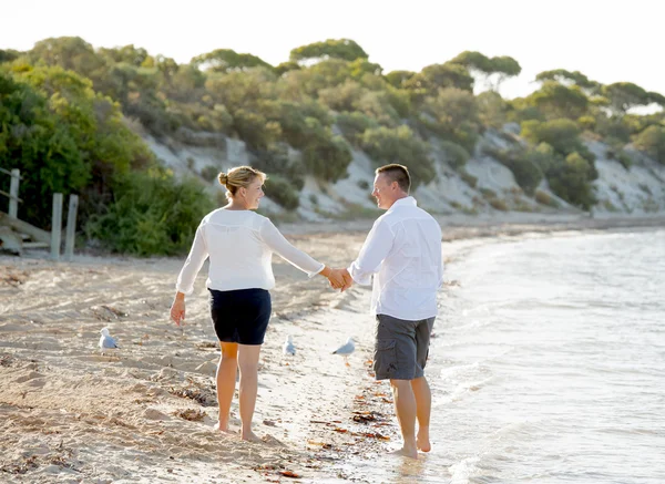 Привлекательная красивая пара влюбленных прогулок по пляжу в романтические летние каникулы — стоковое фото