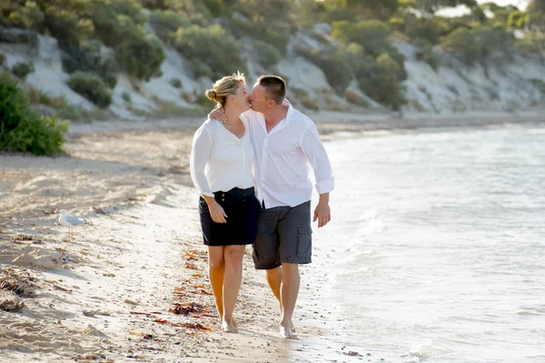 Attractive beautiful  couple in love walking on the beach kissing in romantic summer holidays — Stock Photo, Image