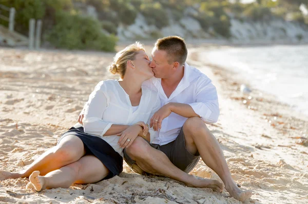 Attraktive schöne verliebte Paar sitzt am Strand in romantischen Sommerferien — Stockfoto