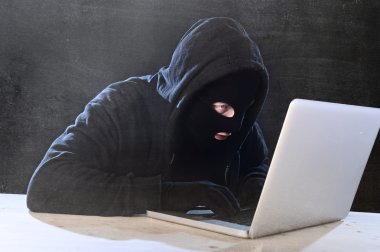 hacker adam siyah kukuleta ve maske ile bilgisayar laptop sistem dijital davetsiz misafir siber suç kavramı kesmek