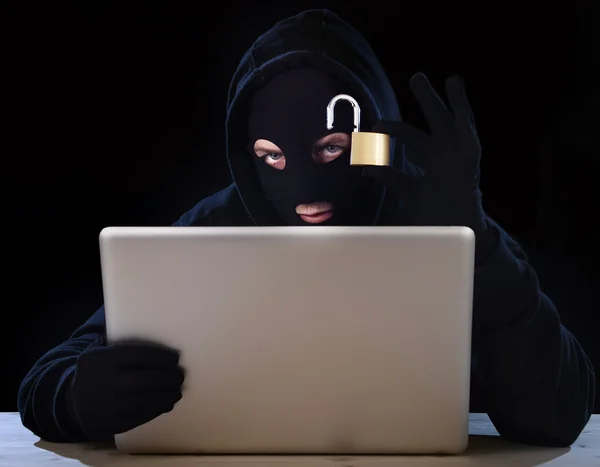 Gevaarlijke hacker man met computer en lock hacking systeem in cyber misdaad concept — Stockfoto