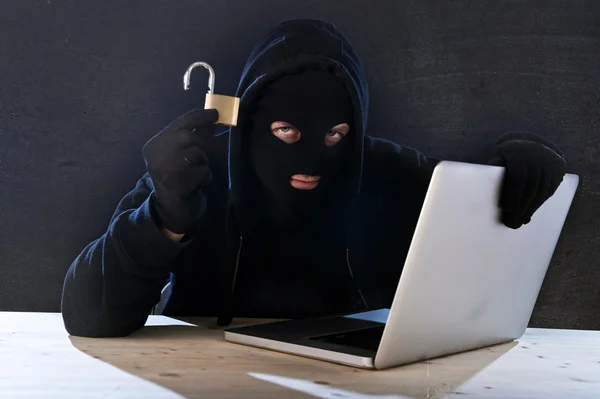 Hombre hacker peligroso con computadora y sistema de piratería de bloqueo en concepto de delito cibernético —  Fotos de Stock