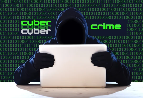 Hacker man in black hood and mask with computer laptop hacking system in digital intruder cyber crime concept — Stock Photo, Image