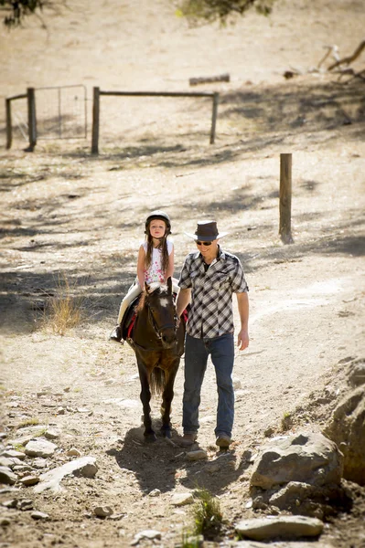 Jeune jockey enfant équitation poney plein air heureux avec père rôle comme instructeur de cheval dans cow-boy look — Photo