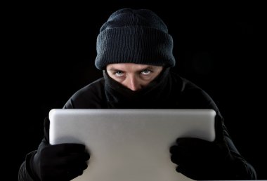 hacker man in black using computer laptop for criminal activity hacking password and private information clipart