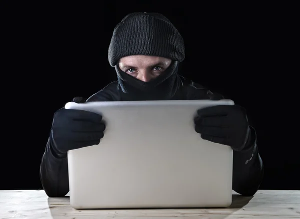 Hacker man in black using computer laptop for criminal activity hacking password and private information — Stock Photo, Image