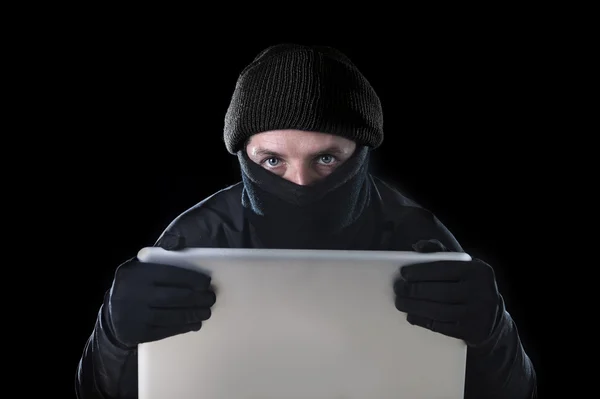 Homem hacker em preto usando laptop de computador para a atividade criminosa hacking senha e informações privadas — Fotografia de Stock