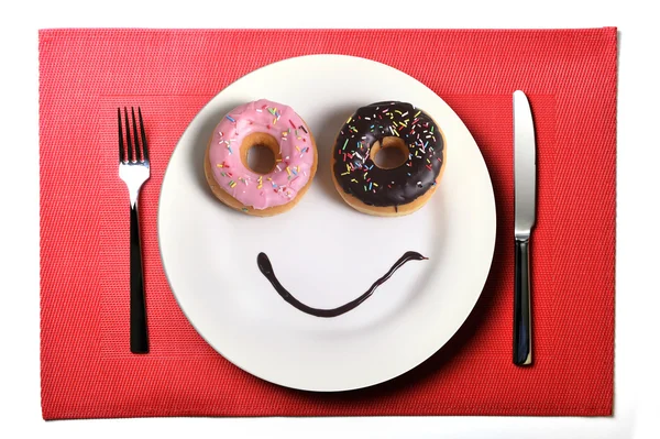 Smiley glada ansikte gjorde på maträtt med donuts ögon och choklad sirap som leende i socker och sweet addiction nutrition — Stockfoto