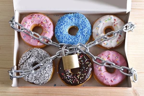 box full of tempting delicious donuts wrapped in metal chain and lock in sugar and sweet addiction