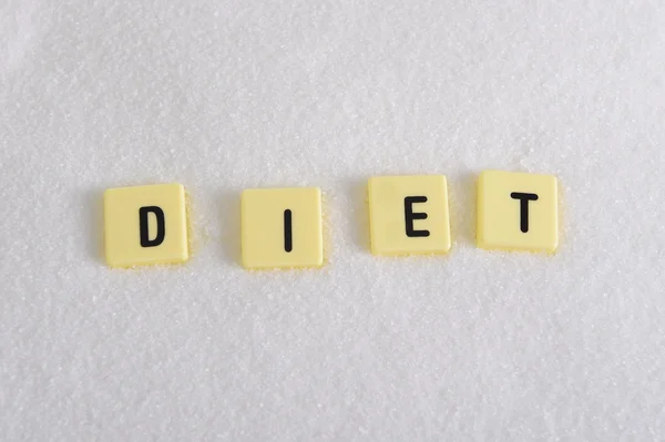 Diät-Blockbuchstaben im Kreuzworträtsel über Zuckerhaufen isoliert auf süßkörnigem weißem Zucker Textur in Diät und gesunde Ernährung — Stockfoto