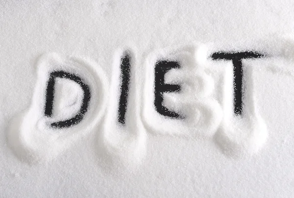 ダイエット ダイエットと健康的な栄養の概念で砂糖の山の上に指で書かれた単語 — ストック写真