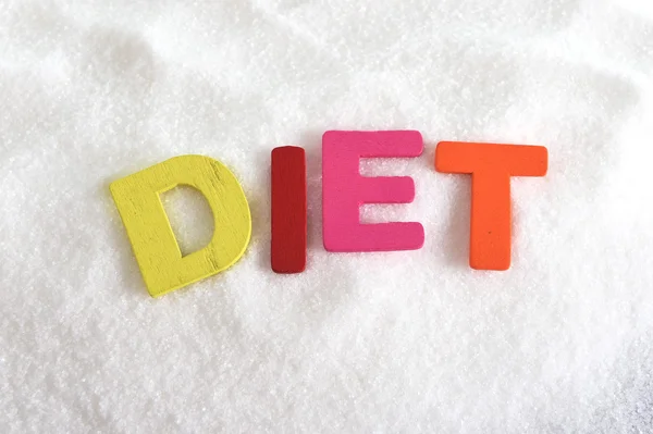 Dieet kleur brieven in kruiswoordraadsel over suiker stapel geïsoleerd op zoete korrelig witte suiker textuur in op dieet zijn en gezonde voeding — Stockfoto
