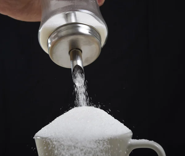 Hombre mano con azucarero verter un lote loco en taza de café completa en concepto de adicción —  Fotos de Stock