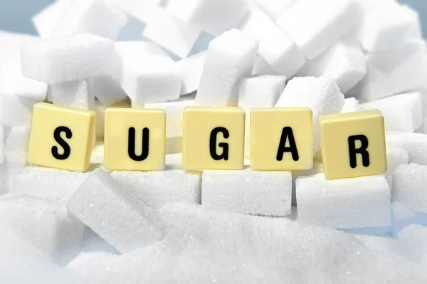 Sugar block letters word on pile of sugar cubes close up in addiction concept — Stock Photo, Image