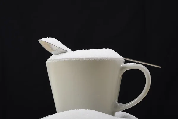 装满糖休息上凌乱咖啡杯疯狂糖成瘾和不良的营养状况的勺子 — 图库照片
