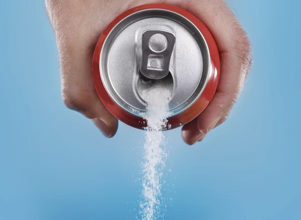 Hand hält Sodadose Gießen eine verrückte Menge Zucker in Metapher für den Zuckergehalt eines Erfrischungsgetränks lizenzfreie Stockfotos