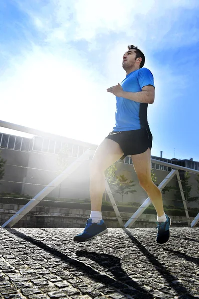 Young athletic man practicing running in urban background backlight in fitness sport training and healthy lifestyle concept — Stock Photo, Image