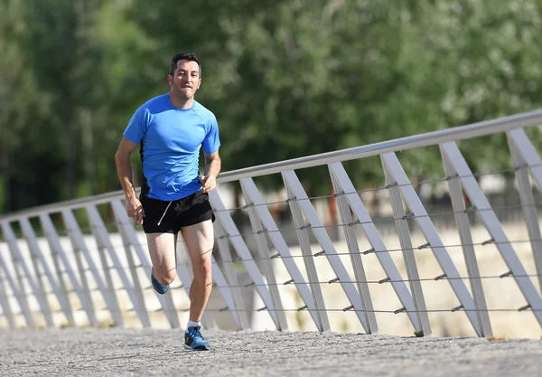 Young athletic man practicing running and sprinting on urban city park background in sport training — Stock Photo, Image