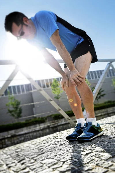 Hombre agotado después de correr en el parque urbano de la ciudad tomando un descanso respirando para recuperarse — Foto de Stock