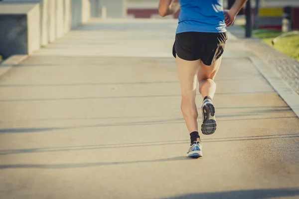 Terug weergave van benen en schoenen van jonge atletische man loopt in zomer fitnesstraining — Stockfoto