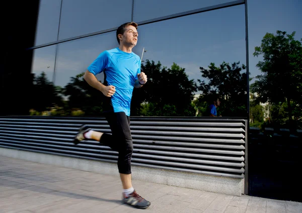 Young attractive man running and training on urban street background on summer workout in sport practice — Stock Photo, Image