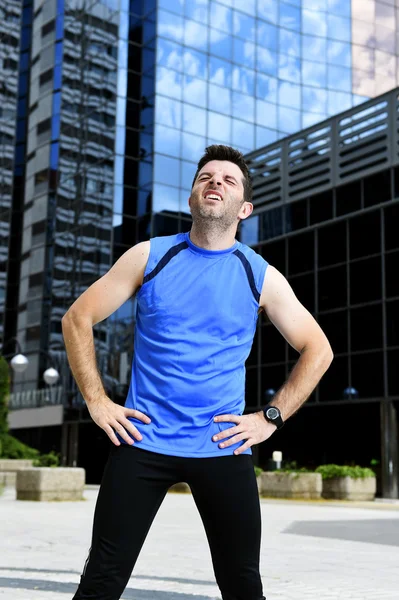 Young sport man breathing exhausted after running training on city urban background standing tired — Stock Photo, Image