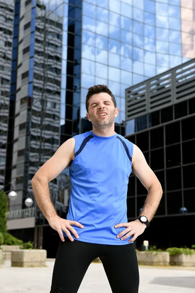 Young sport man breathing exhausted after running training on city urban background standing tired — Stock Photo, Image