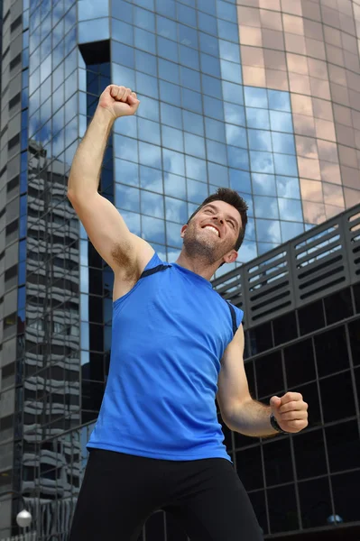 Attraktiver Sportler bei Sieg und Siegerzeichen mit den Armen nach Lauftraining im städtischen Geschäftsviertel — Stockfoto