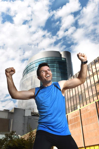 Attraktiver Sportler bei Sieg und Siegerzeichen mit den Armen nach Lauftraining im städtischen Geschäftsviertel — Stockfoto