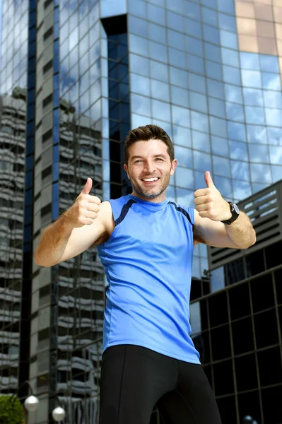 Sport man doen overwinning winnaar duimen omhoog na het lopen opleiding in stedelijke zakelijke district — Stockfoto