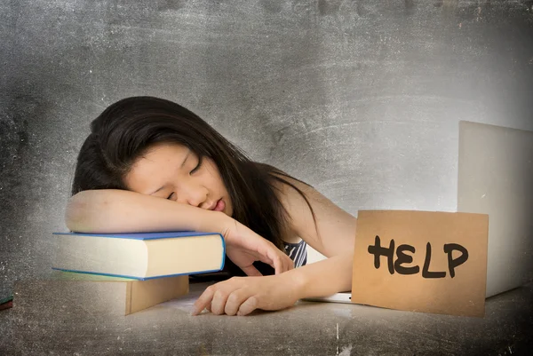 Young pretty Asian Chinese woman student asleep on her laptop studying overworked with help sign on her desk — Stockfoto