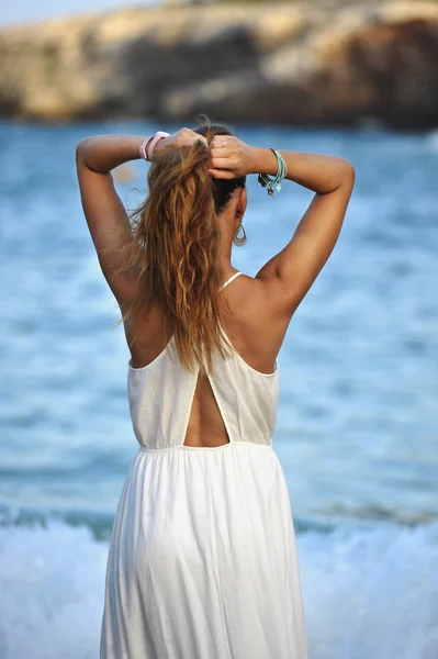 Giovane donna guardando acqua di mare in vacanza estiva prendendo coda di cavallo sui capelli godendo di vacanza rilassata — Foto Stock