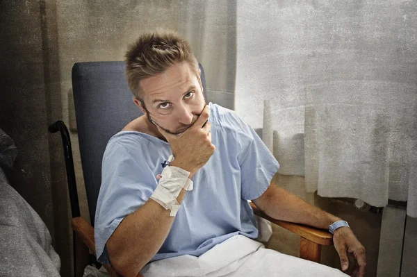 Jovem ferido homem no quarto do hospital sentado sozinho com dor preocupado com a sua condição de saúde — Fotografia de Stock