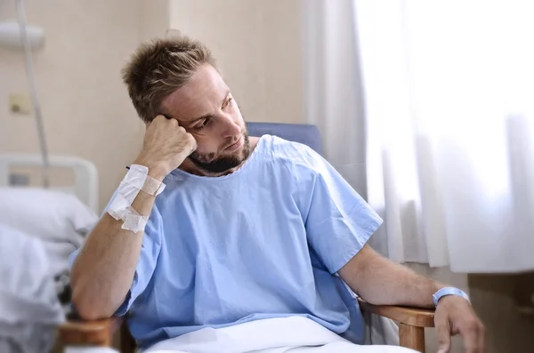 Gewonde jongeman in ziekenhuis kamer zitten alleen in pijn bezorgd voor zijn gezondheidstoestand — Stockfoto