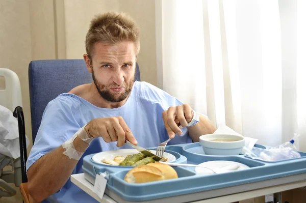 Man in hospital room eating healthy diet clinic food in upset moody face expression — 스톡 사진