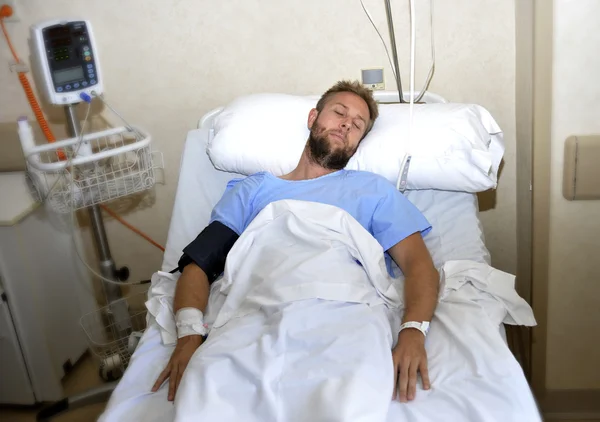 Травмований чоловік лежить у лікарняній кімнаті, що відпочиває від болю, дивлячись у поганому стані здоров'я — стокове фото