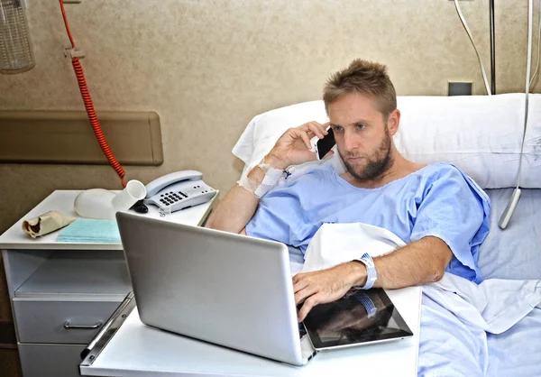 Hombre de negocios adicto al trabajo en la habitación del hospital acostado en la cama enfermo y herido trabajando con el ordenador portátil del teléfono móvil —  Fotos de Stock