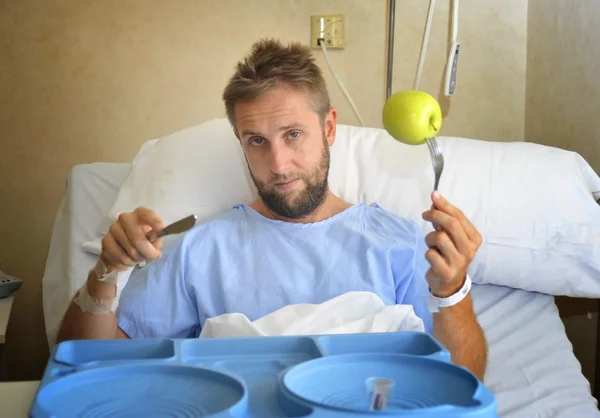 Joven en la habitación del hospital después de sufrir un accidente comer saludable dieta de manzana clínica comida malhumorada y triste — Foto de Stock